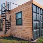 Modern shipping container home with wood slat exterior and black trim